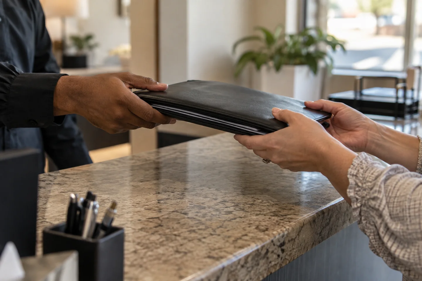A document handover between two people at an office reception.